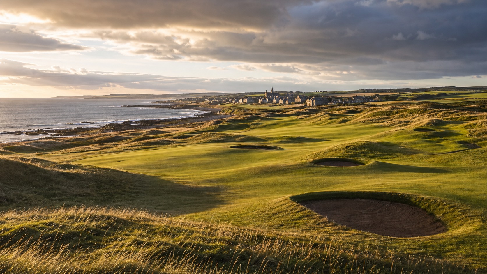 panoramic Scottish seaside links course with stone clubhouse, photographed in a wide editorial landscape
